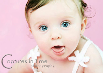 toddler on pink backdrop with tongue hanging out