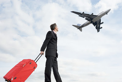 Businessman+Holding+Suitcase+Watching+Plane.jpg