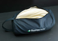 a black bag with a white blanket inside