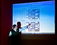 a man pointing at a projector screen