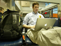 a man sitting on a chair using a laptop