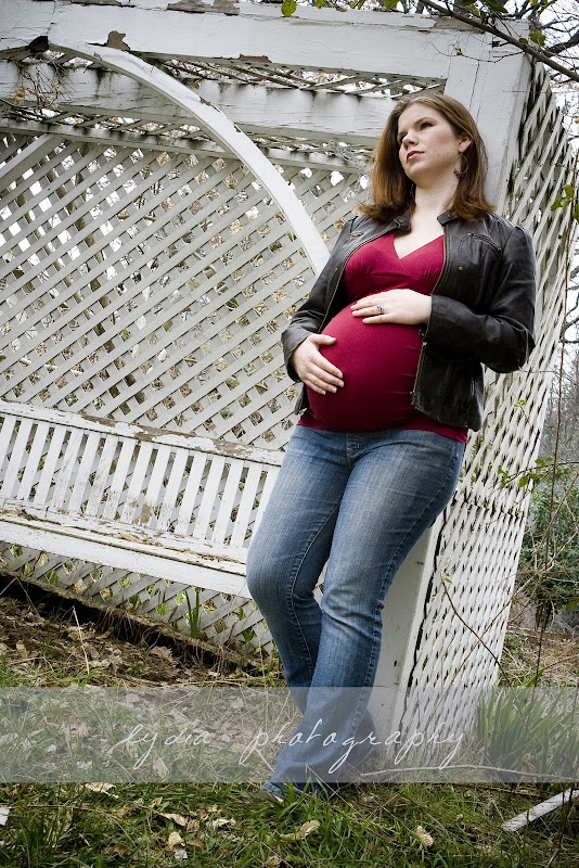 Hands on belly and standing up against and arch at lifestyle maternity portraits in Grass Valley, California
