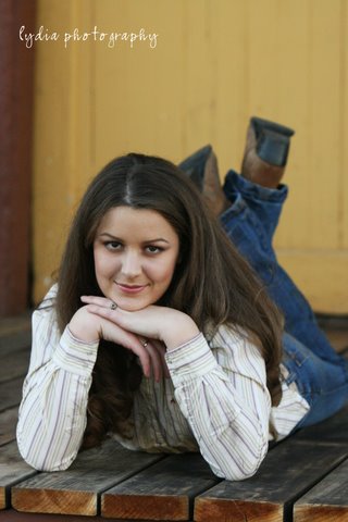 Senior laying on the wooden floor at lifestyle senior portraits in Colfax, California