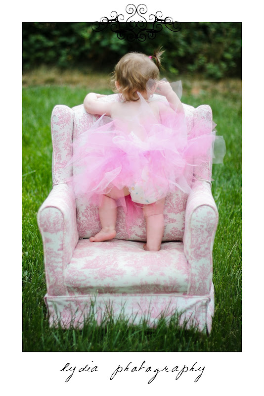 Baby standing on pink chair at lifestyle baby portraits in Grass Valley, California