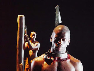 Slave with collar that hurts stuck to a trunk.  Another slave chained to another trunk in the background.