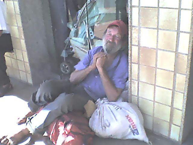 Mendigo idoso esmola à porta do Banco do Brasil em Tangará