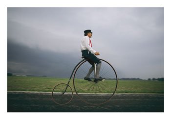 [A-Man-Pedals-an-Old-Fashioned-Bicycle-Ahead-of-an-Indiana-Thunderstorm-Photographic-Print-C10243490.jpeg]