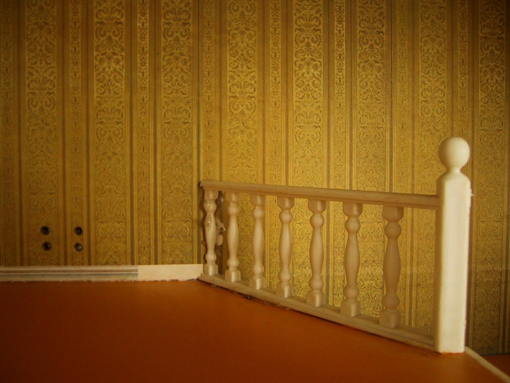 White plastic rails at the top of the stairs in a vintage Lundby dolls' house.