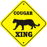 Yellow sign that reads cougar crossing, with a black silhouette of a cougar on it