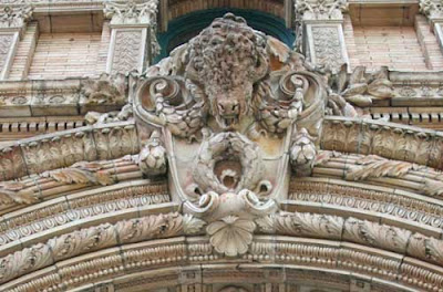 Buffalo, three dimensional, tan, above the arched doorway of a building