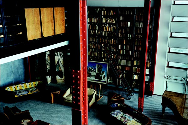 [Maison+de+verre+-+The+bookcase+with+metal+shelving+has+a+ladder+that+slides+along+the+length+of+the+shelves.+The+cupboards+and+bookshelves+were+designed+as+screens+to+the+second+floor.jpg]