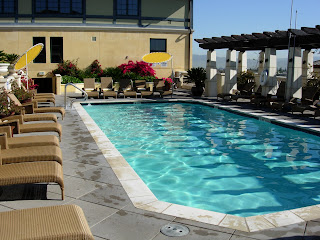 a pool with chairs and a pergola