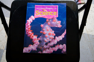 Science textbook on a chair, cover has a seahorse