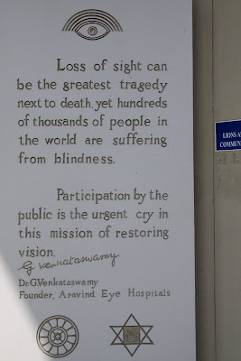 Wall-plaque with the words: <br />Loss of sight can be the greatest tragedy next to death, yet hundreds of thousands of people in the world are suffering from blindness.  Participation by the public is the urgent cry in this mission of restoring vision.  Dr. G. Venkataswamy, Founder, Aravind Eye Hospitals<br />