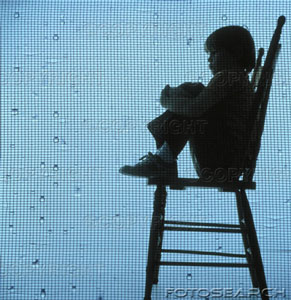 [young-child-sitting-on-a-tall-wooden-chair-as-rain-is-falling-on-the-~-PDC1050.jpg]