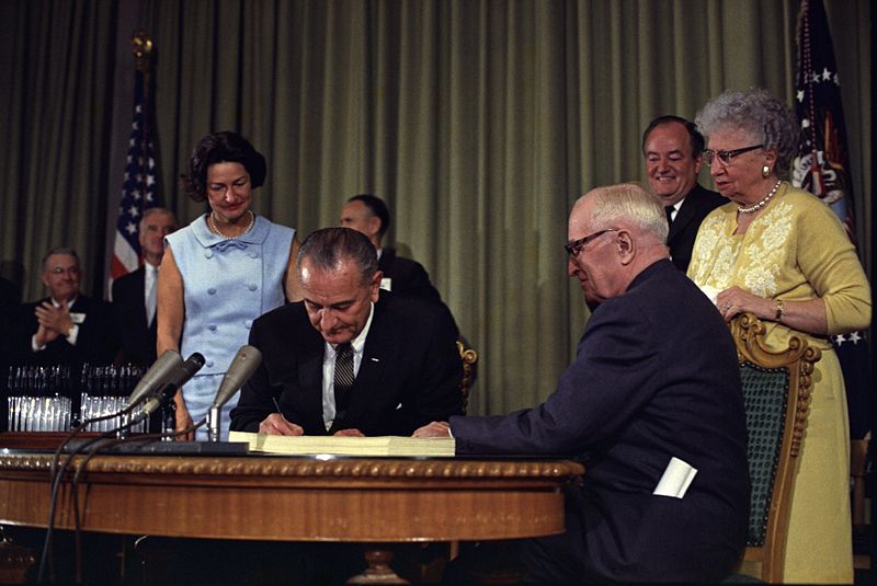 [Johnson_signing_Medicare_bill,_with_Harry_Truman,_30_July,_1965.jpg]