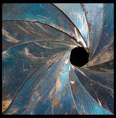 Photograph of the scarred, rusted aperture blades of an old lens