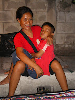 Thai woman cradling her sleeping son